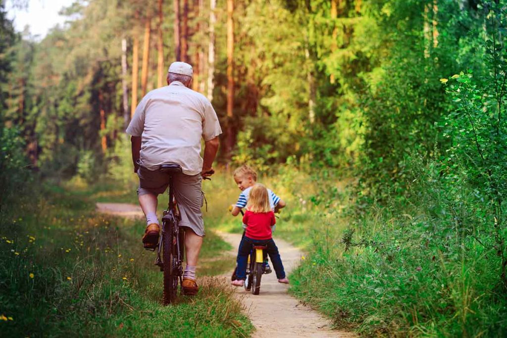 Un papy fait du vélo avec ses petits-enfants.