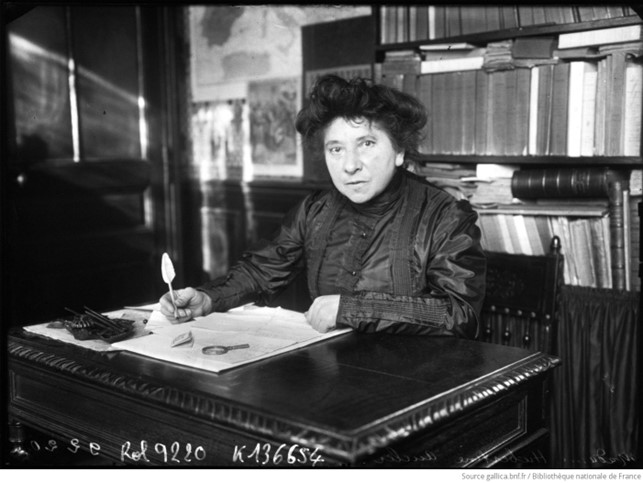 Photographie d'Hubertine Auclert écrivant à son bureau