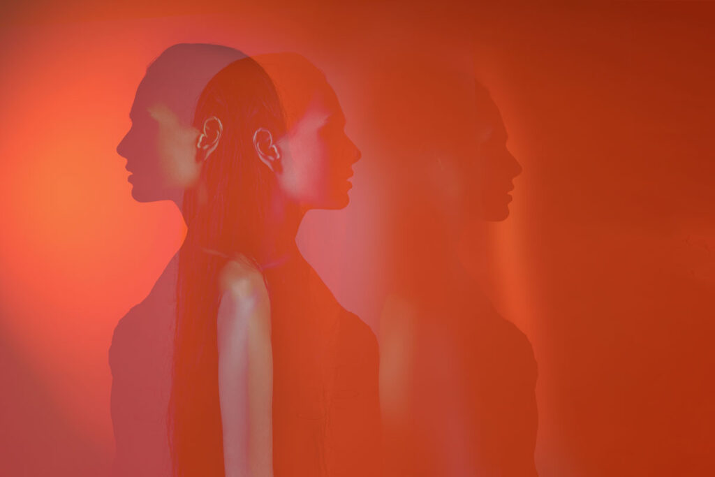 Plusieurs silhouettes de la même femme floues sur fond rouge