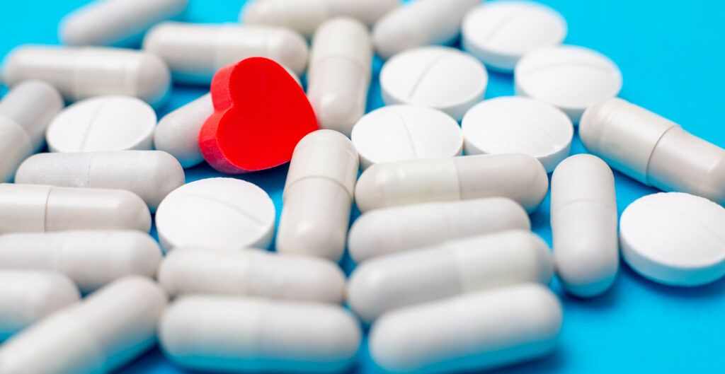 Pilules de médicaments et coeur rouge