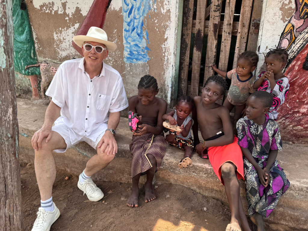 André Mermoud dans un village africain, entouré d'enfants