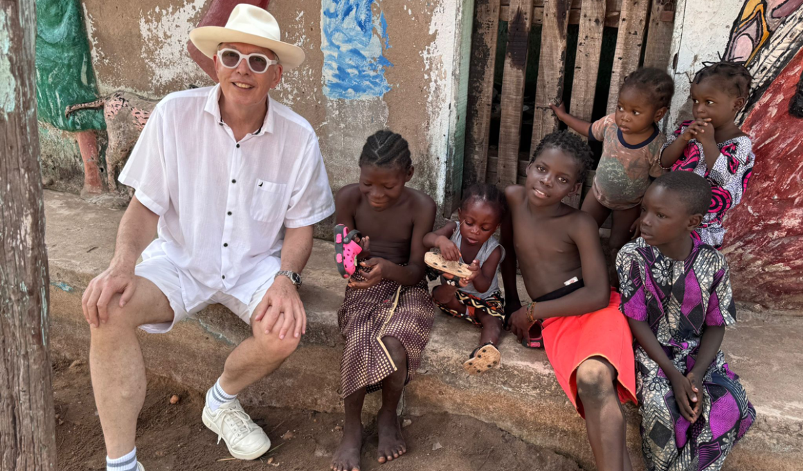 André Mermoud dans un village africain, entouré d'enfants